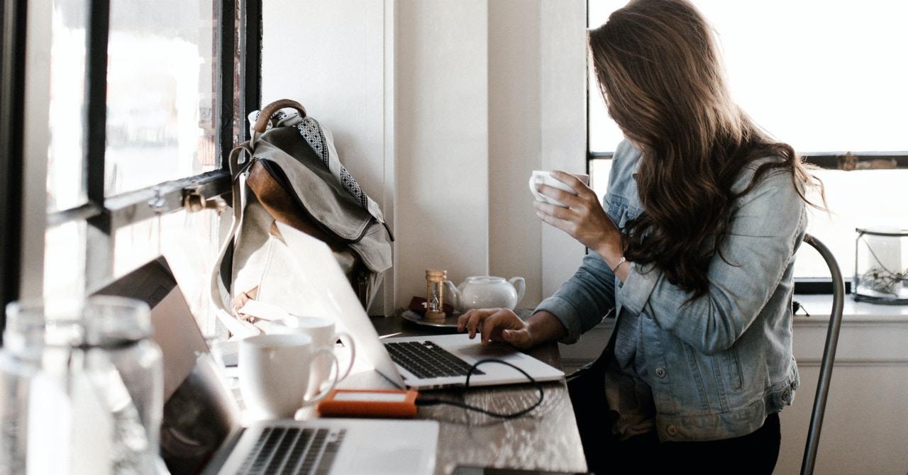 Back pain after sitting all day. Girl sits at a desk, working on a laptop