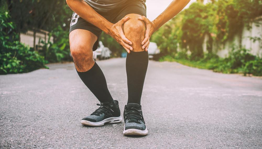 Man running and experiencing knee pain
