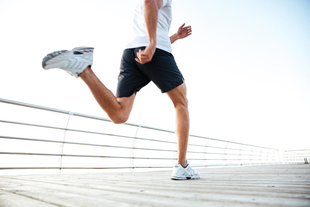 Man running along boardwalk related to blog on how long should you wait to run after a torn ACL injury