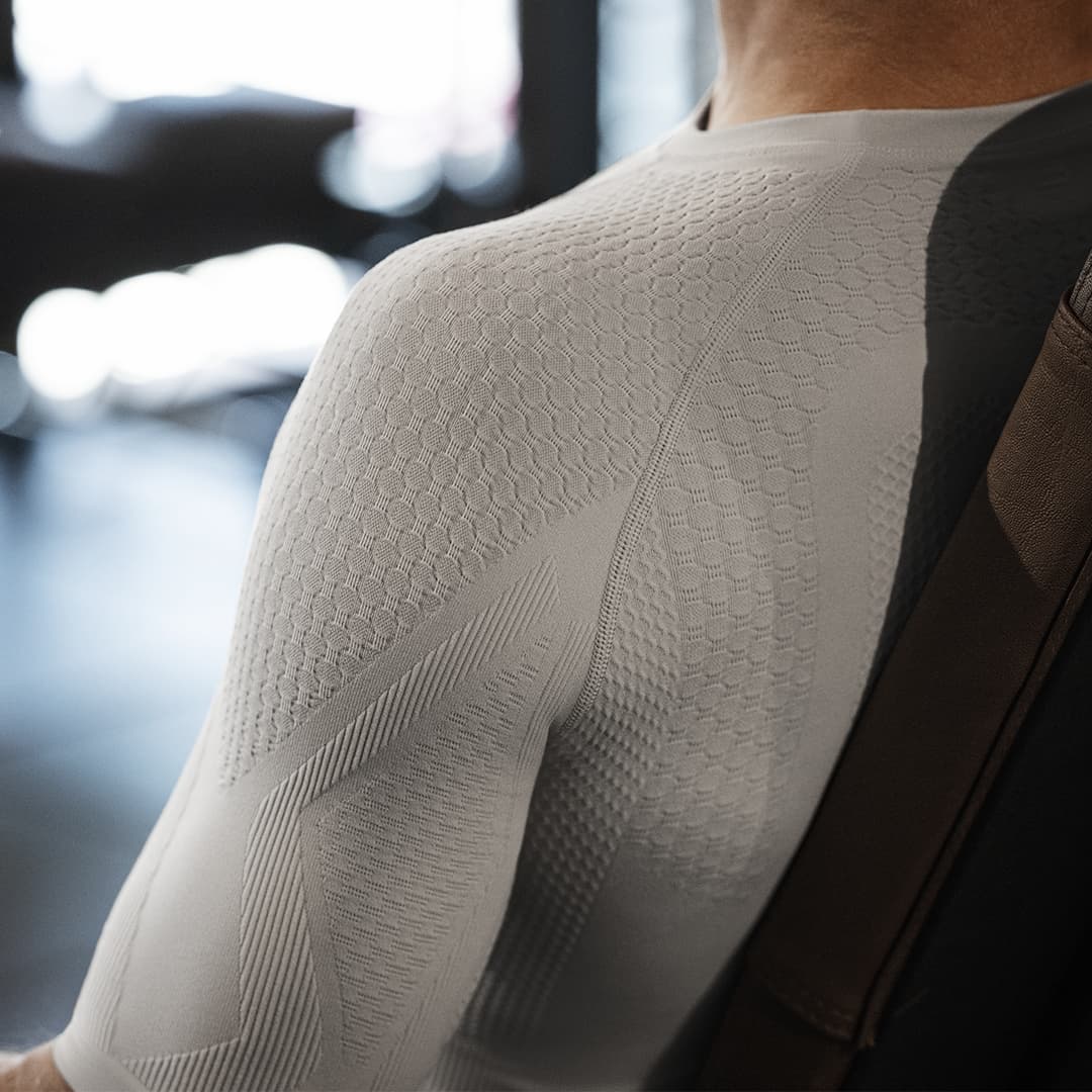 Person wearing a textured Bauerfeind compression shirt with a blurred background