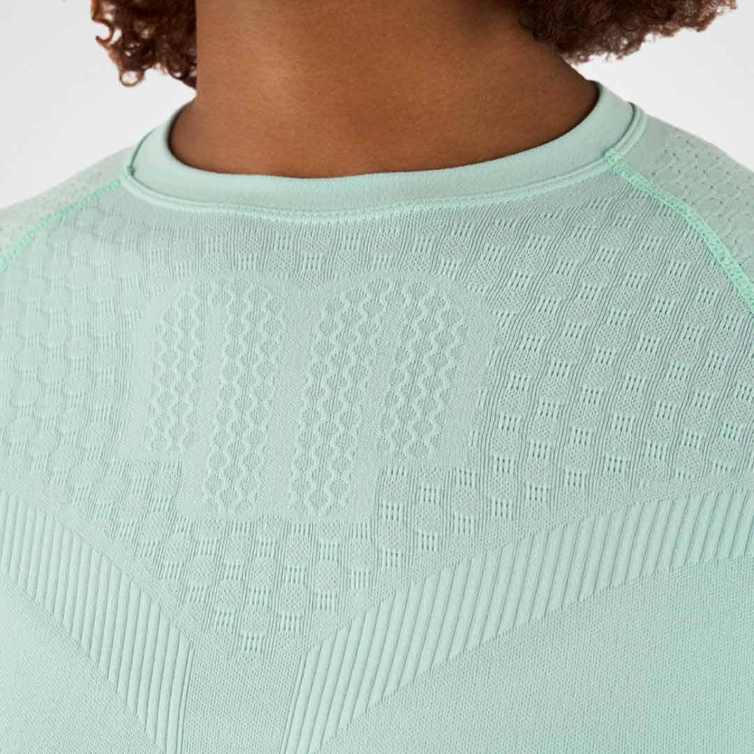 Close-up of a light green textured Bauerfeind compression shirt on a neutral background