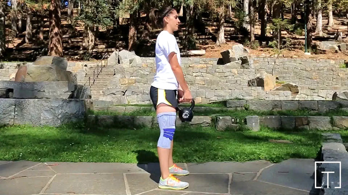 Woman doing kettlebell squats at the park