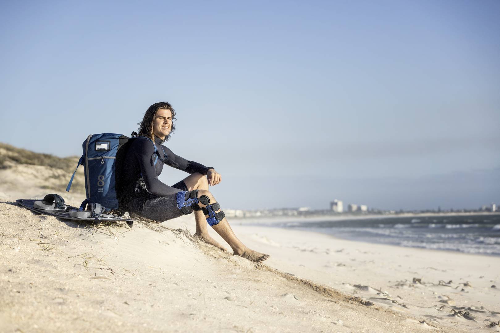 man on the beach wearing an ACL knee brace
