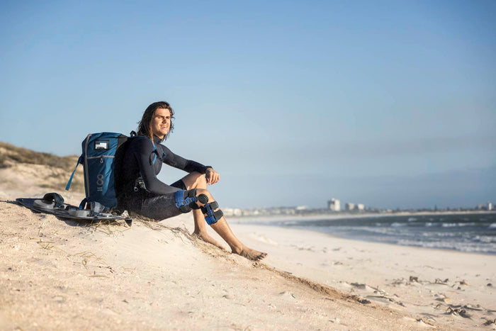 man on the beach wearing an ACL knee brace