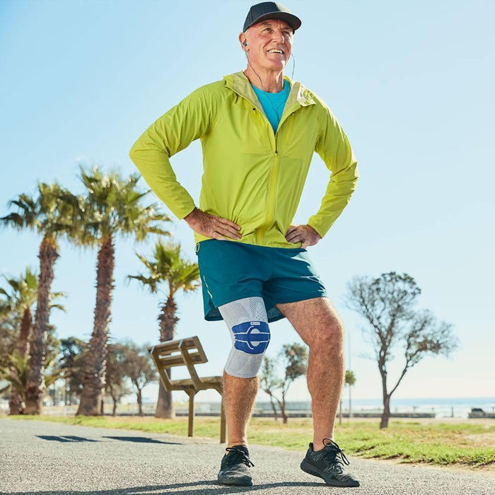 Man in park wearing exercise clothes and the Bauerfeind GenuTrain knee brace. Clock lunges: at-home strength exercise