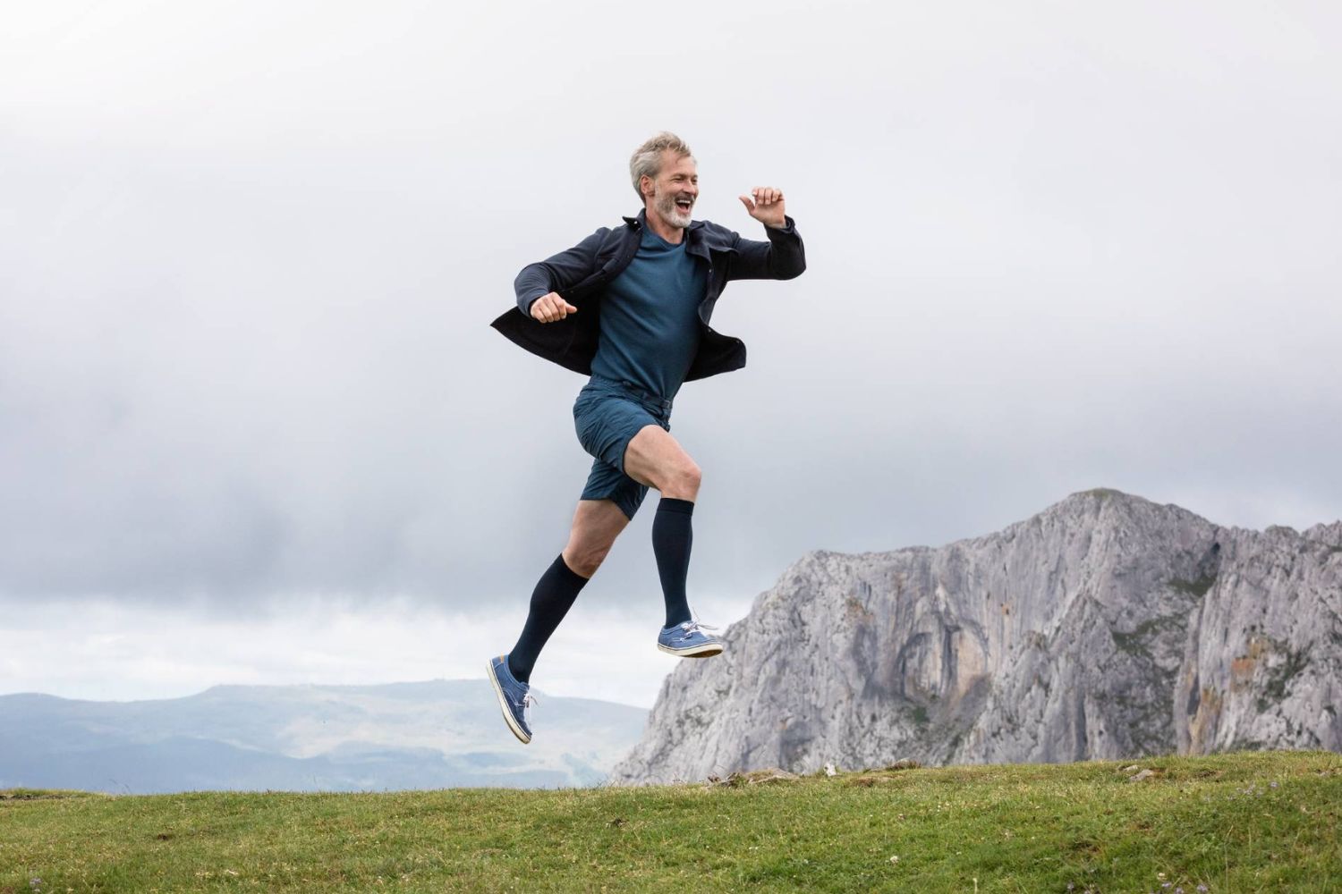 man jumping on a cliffside walk in Bauefeind VenoTrain Compression Socks