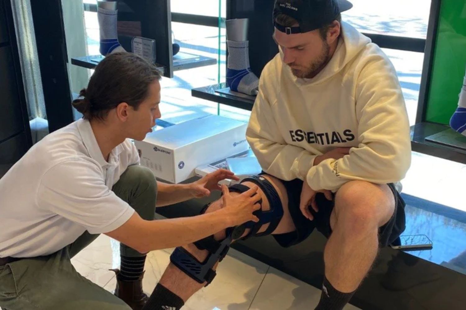 bauerfeind technician helping to fit a secutec knee brace