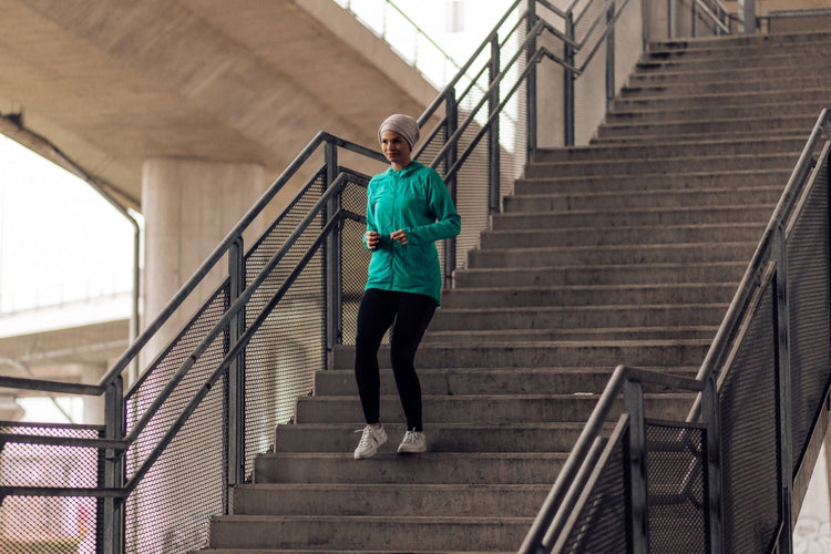 woman doing step-downs on the stairs