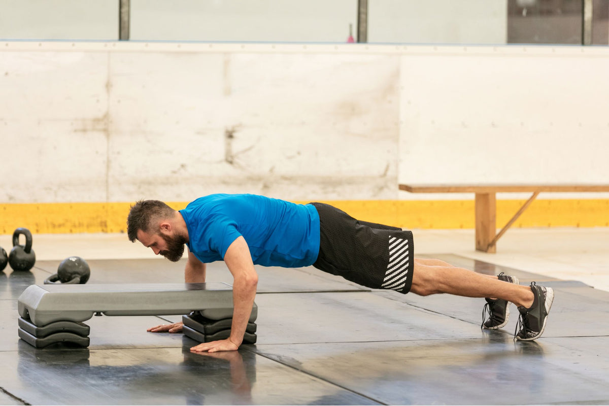 man doing hand step-ups split exercise at the gym