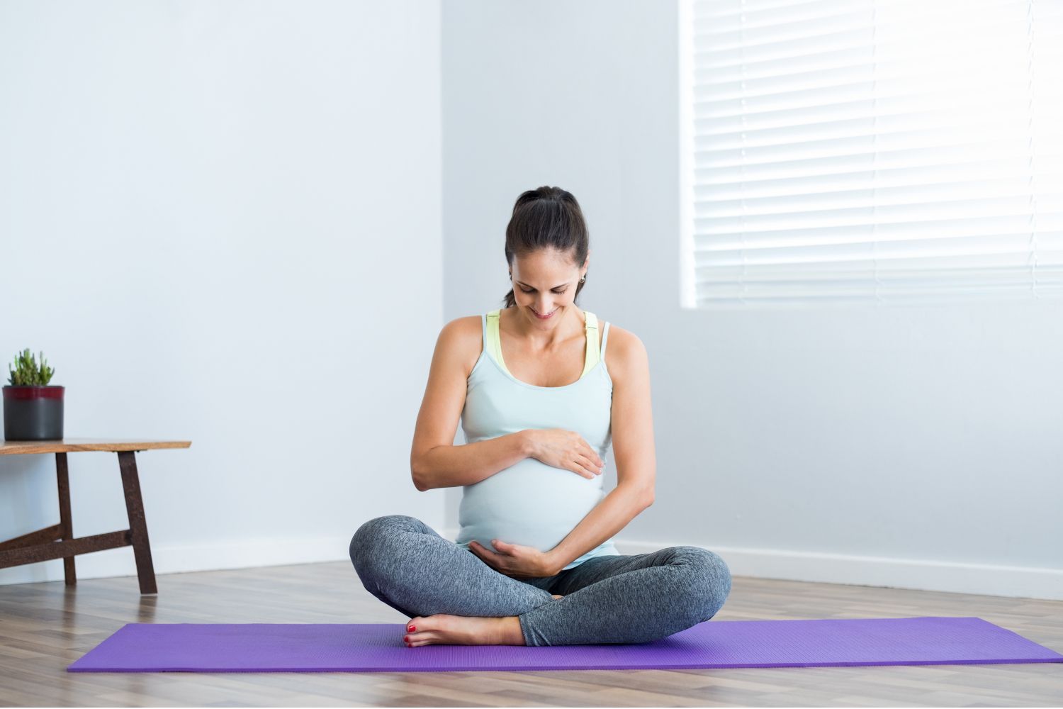 pregnant woman sitting on a yoga mat