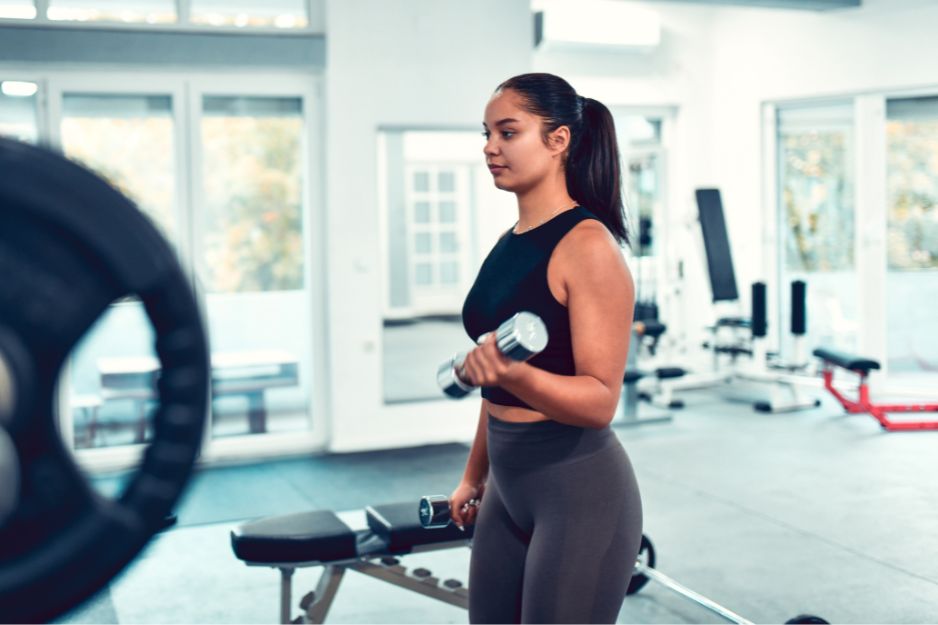 woman doing bicep curls at the gym