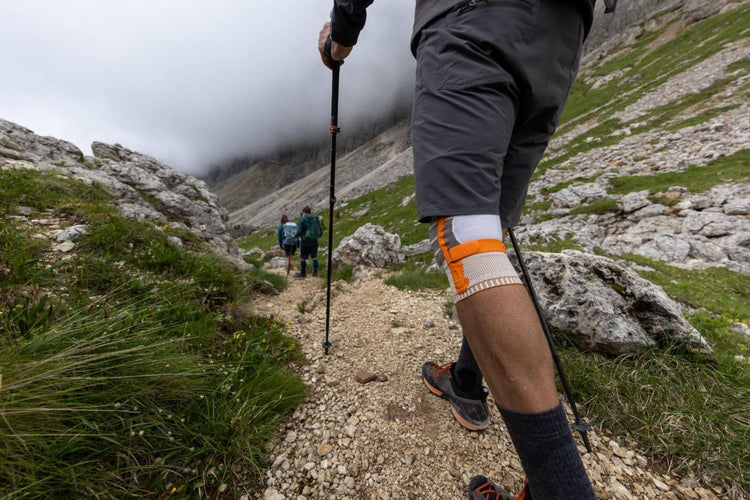 man hiking through some rocky mountains. He is wearing Bauerfeind's Outdoor Knee Support