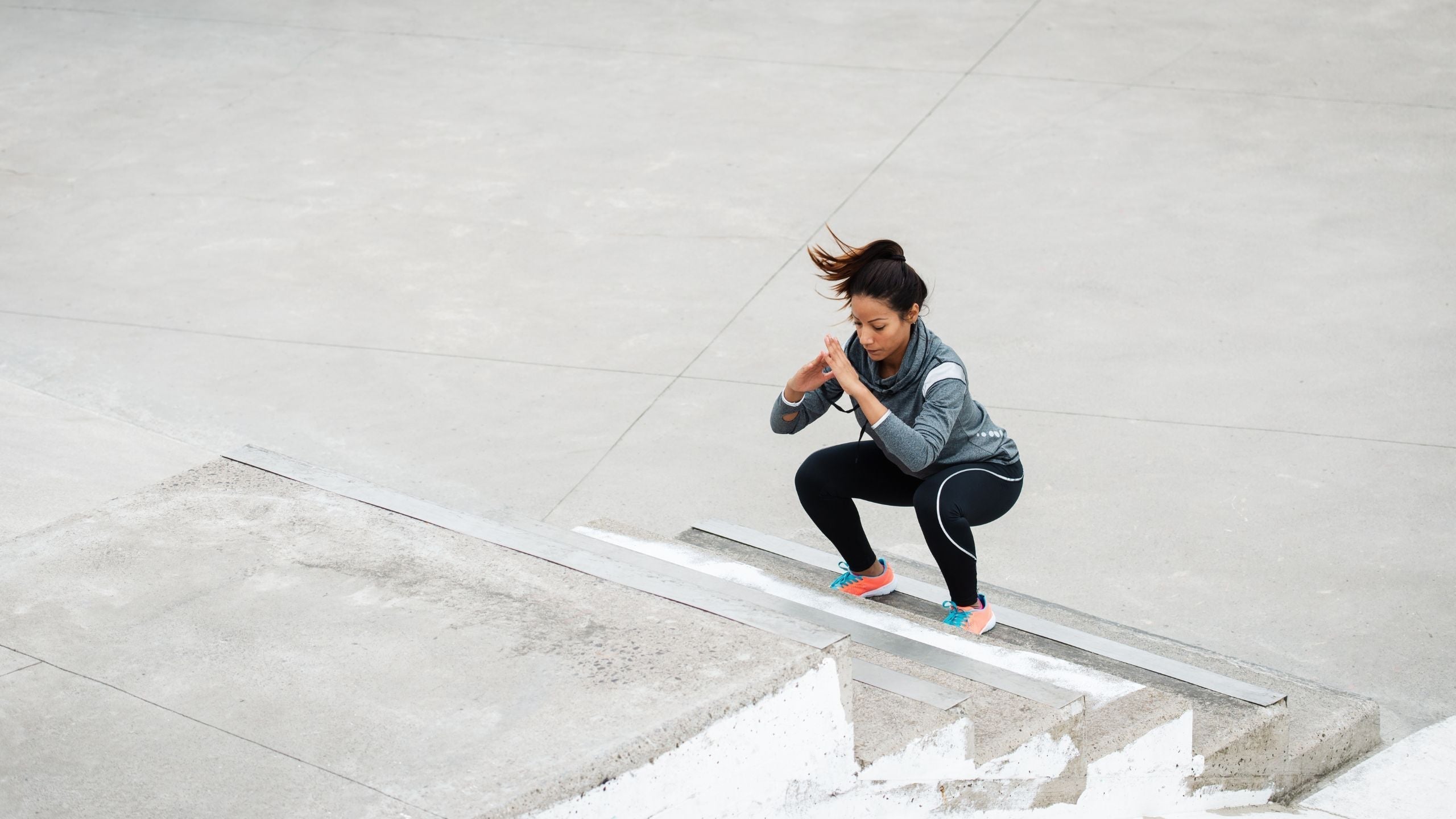 woman doing jump squats on a stairwell