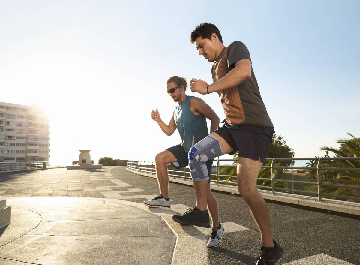 Two men doing exercises on a step, one man is wearing the Bauerfiend knee brace for strength building after injury. 