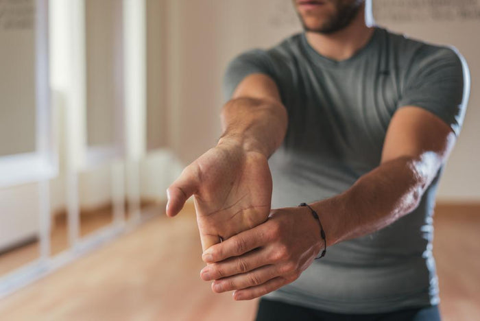 Catch and Release Wrist Throws: at-home strength exercise. Man holding one arm out, stretching his hand backwards