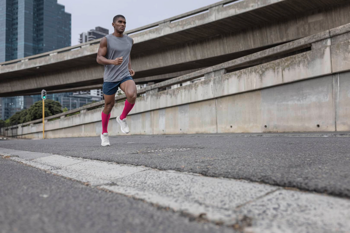 man running in calf compression sleeves to avoid calf injury and pain