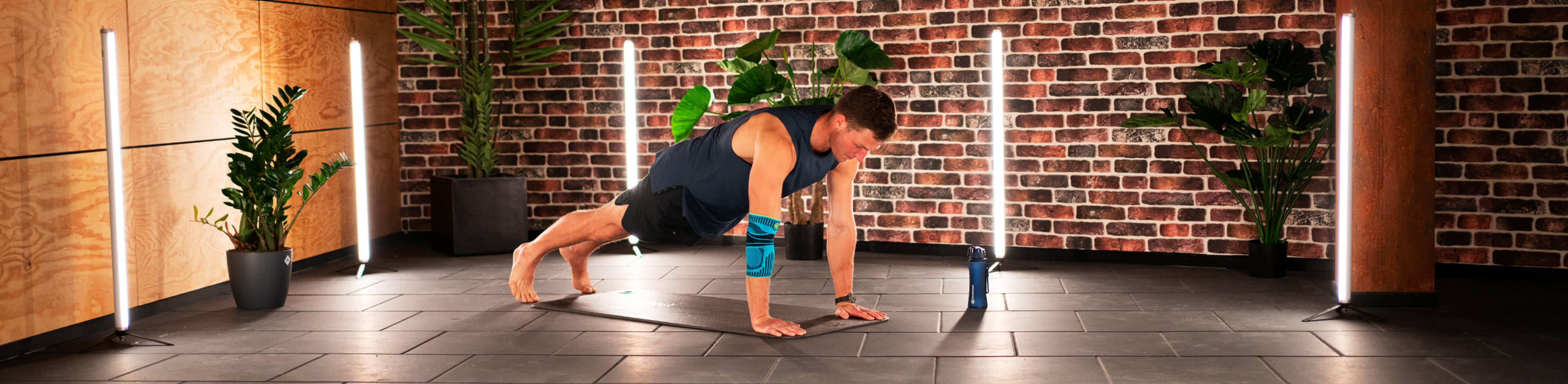 Thomas Roehler performing the plank taps workout for core and arm strength. He is wearing Bauerfeind's Sports Elbow Support