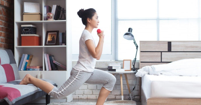 Woman performing split squats at home using her couch