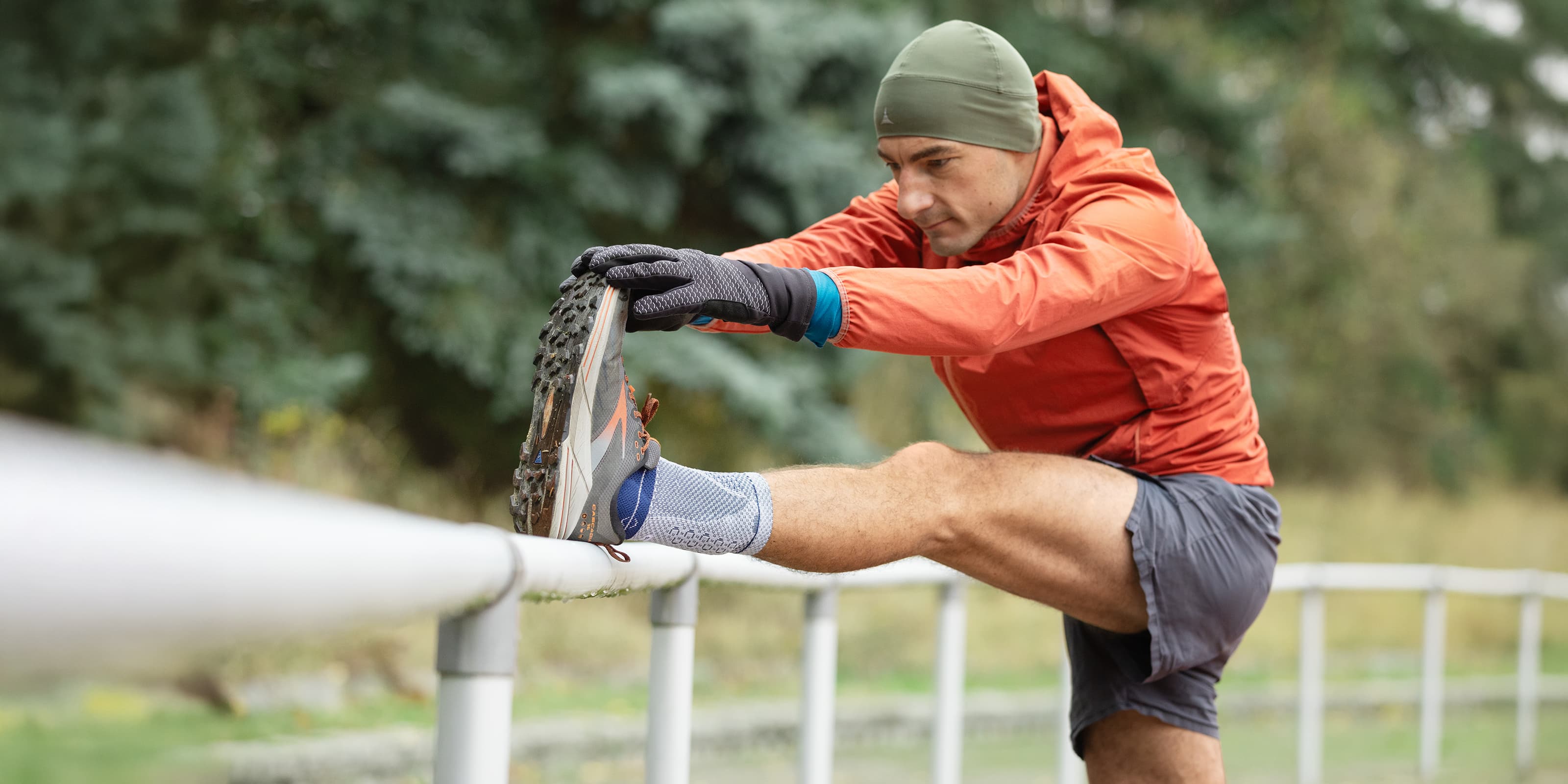 A man stretching wearing a Bauerfeind an AchilloTrain Pro Ankle Support
