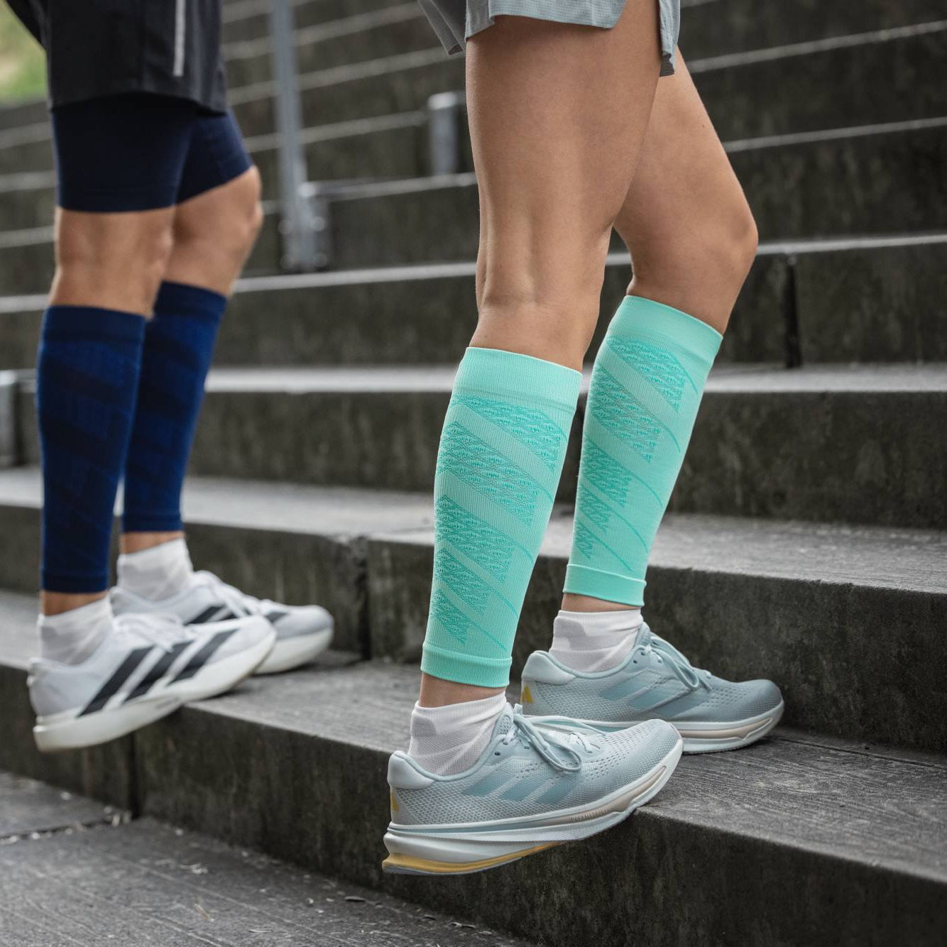 Two people wearing compression socks on a staircase