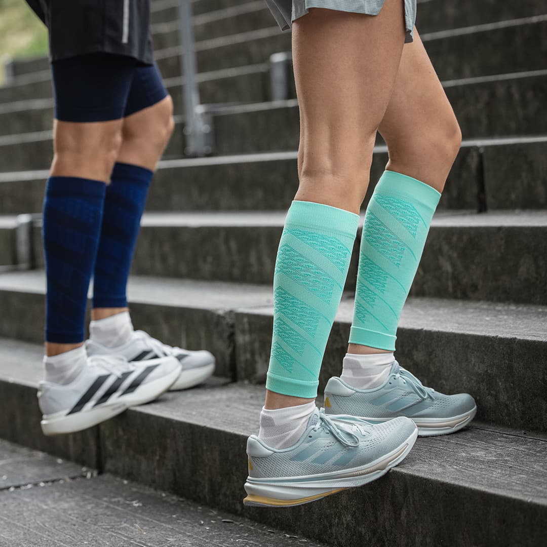 Two people wearing compression socks on a staircase
