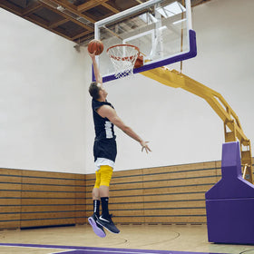 Person dunking a basketball in an indoor gym setting