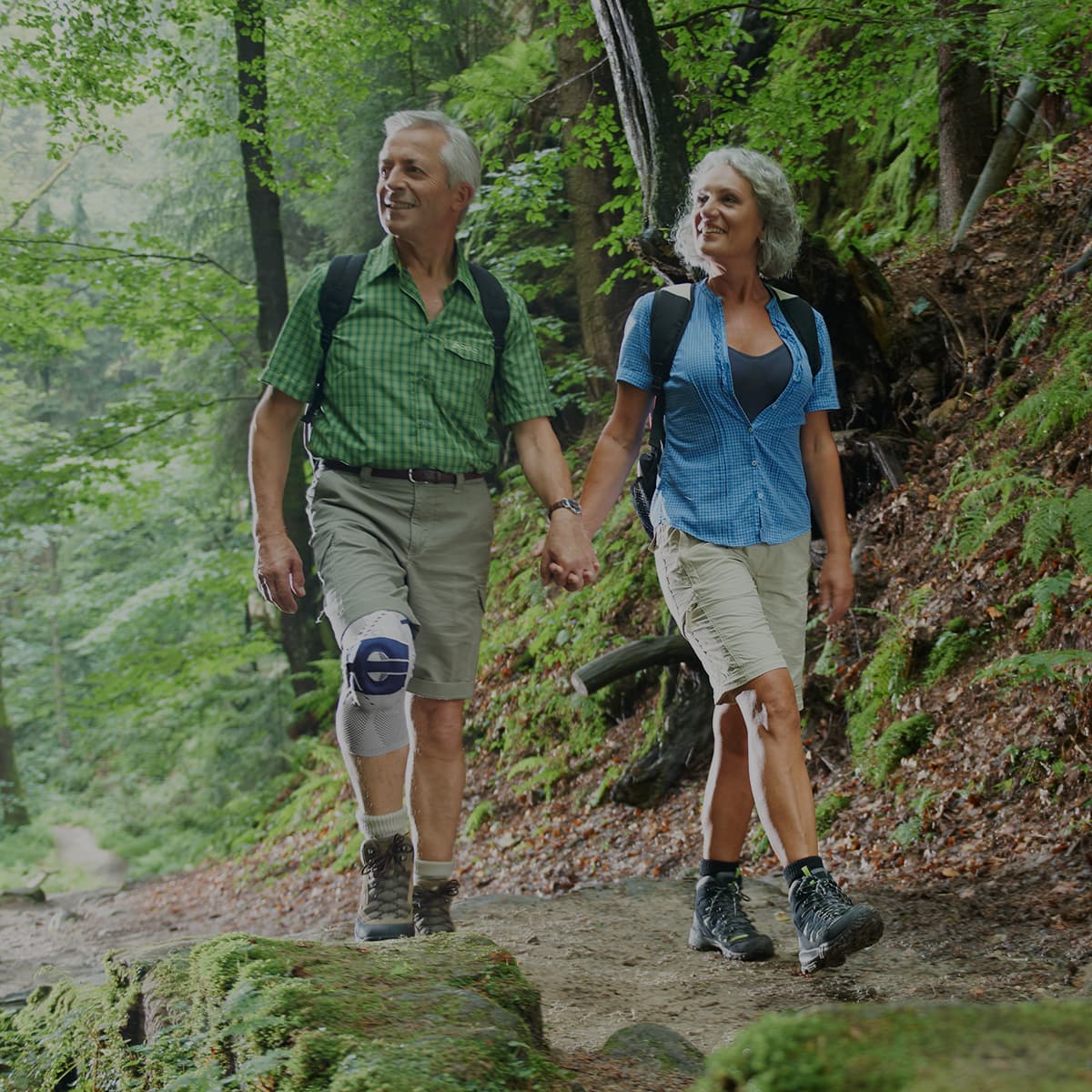 An older couple going on a hike with the man wearing a Bauerfeind GenuTrain A3 Support