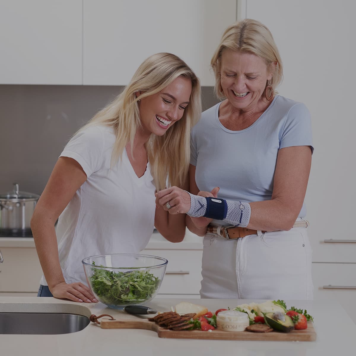 A mum and daughter in the kitchen where the mum is wearing a Bauerfeind ManuTrain wrist support